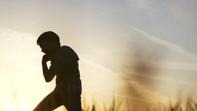 silhouette child kid boxer. boy a boxing with shadow exercising at sunset outdoor. kid dream. sport victory healthy lifestyle concept sun. child shadow boxing little champion boxer silhouette