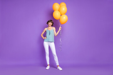 Fototapeta na wymiar Full length body size view of lovely cheerful girl holding balls posing isolated over bright violet purple color background