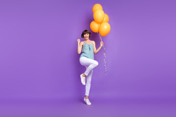 Full length body size view of lovely cheerful lucky girl holding balls dancing isolated over bright violet purple color background