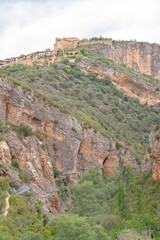 Fototapeta na wymiar Mountain village with unusual iron footbridge anchored in the mountain wall