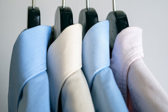 Close-up of hangers with business shirts. Row of colored shirts on a rack. Cloth hanger with casual men shirt.