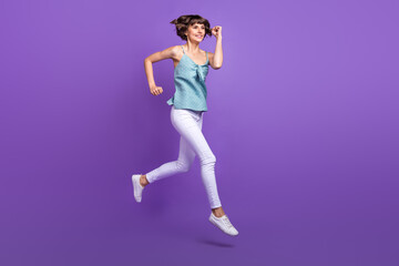 Fototapeta na wymiar Full length body size view of lovely cheerful girl jumping jogging isolated over bright violet purple color background