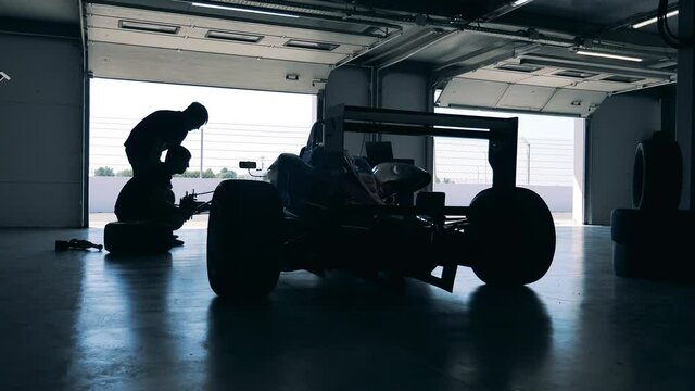 Garage workers are fixing a racing car