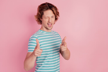 Crazy funny funky positive man direct forefingers you wink eye on pink wall