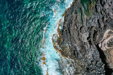 Aerial view of ocean waves, birdseye view of waves and rocks, blue waves and rocks, beautiful deep blue waves, amazing aerial view of coastline with deep blue waves and rocks. Tenerife, Canary Islands