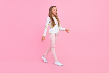 Profile photo of positive nice carefree small lady walk wear dotted shirt pants footwear isolated pink color background