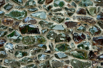 Glass fiber melt multicolored blocks cemented on facade concrete wall as modern architectural decorative decision of broken glass recycling. Durable, weatherproof outdoor molten glass stones texture