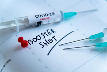 Third covid vaccine dose and jab concept. Three syringes are seen on calendar as a concept for the 3rd covid-19 vaccine dose, also called booster shot, now requested during the vaccination campaign. - obrazy, fototapety, plakaty
