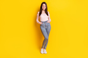 Fototapeta na wymiar Full size photo of young happy cheerful smiling beautiful girl hold hands pockets isolated on yellow color background