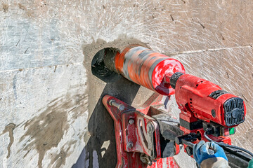 Worker is drilling to concrete wall with core drill machine. Core drills used in metal are called...