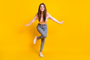 Fototapeta na wymiar Full size photo of young happy excited cheerful woman dancing enjoying free time isolated on yellow color background