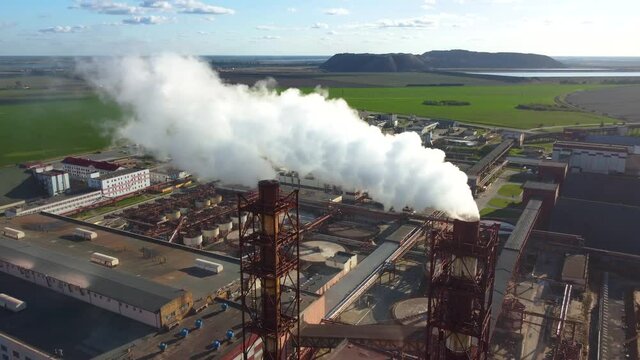 Aerial view of a plant pipes pollute atmosphere. White smoke from the chimney of an industrial enterprise. . High quality 4k footage