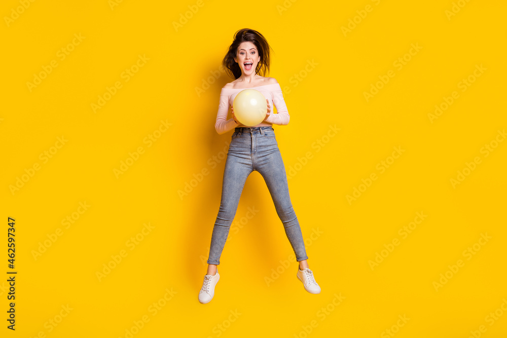 Sticker Full size photo of young happy excited crazy cheerful woman jumping with balloon in hands isolated on yellow color background