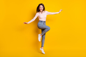 Fototapeta na wymiar Full size photo of young fun excited smiling crazy girl jumping with flying hair isolated on yellow color background
