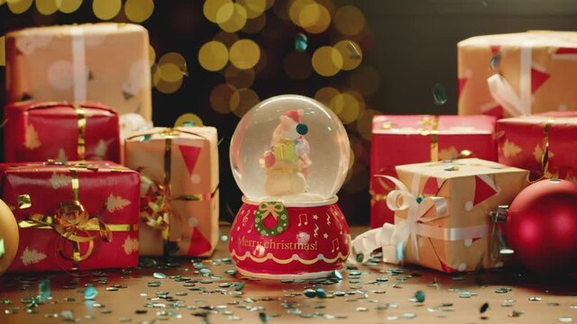 Christmas snowglobe and Christmas gifts on table