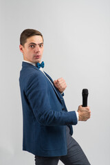 Naklejka premium The entertainer. Young elegant talking man holding microphone, Isolated in studio.
