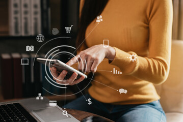 Businesswomen using smartphone with laptop on desk in modern office with virtual interface graphic icons network diagram.