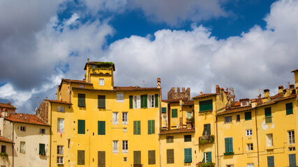 Fototapeta na wymiar Lucca Amphitheater characteristic medieval houses with clouds