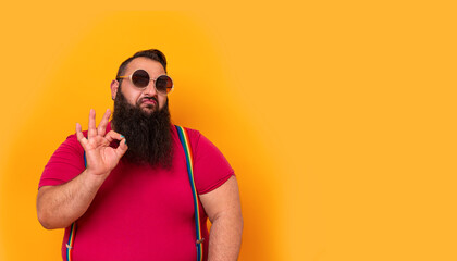 Big funny bearded man wearing sunglasses and doing a perfect hands sign