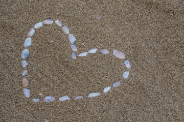 Herzform mit Muscheln im Sand am Strand