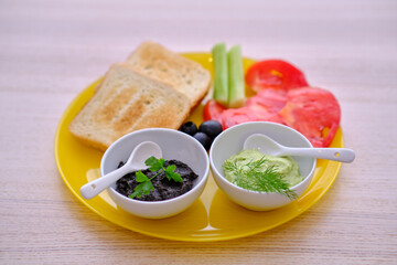 Healthy breakfast with bread guacamole olive paste tomatoes and cucumbers 