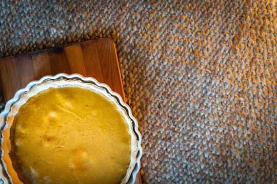 Overhead view of Pumpkin Pie over wooden board and jute carpet with copy space