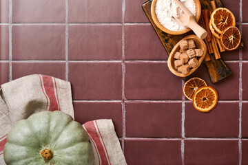 Pumpkin. Autumn food background with cinnamon, nuts and seasonal spices on old ceramic tiles background. Cooking pumpkin or apple pie and cookies for Thanksgiving and autumn holidays. Top view.