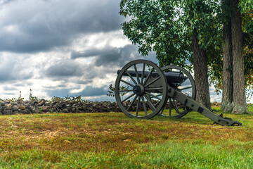 Fototapeta na wymiar Civil War cannons in front of stone wall and colorful field in the autumn 