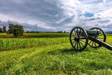 Civil War cannon in front of colorful field with beautiful clouds in the autumn 