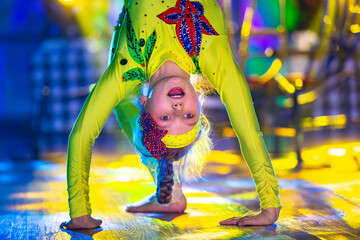Little girls are performing a dance number. Dancing little girl in a beautiful yellow suit upside...