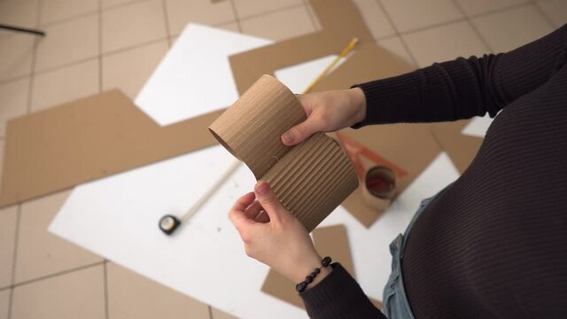 A person neatly divides a strip of cardboard into two parts. Making crafts.