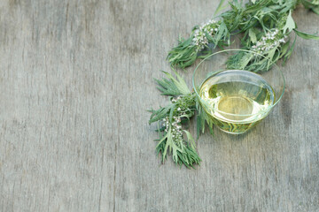 Fototapeta na wymiar Leonurus cardiaca essential oil jar with fresh motherwort flowers on wooden background