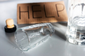 empty glass, bottle of alcohol and lettering help stop alcoholism concept