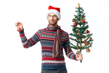 handsome man with a tree in his hands ornaments holiday fun studio posing