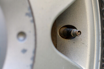 Wheel nipple without cap. Place the air replenishment tires. Toned background with selective focus...