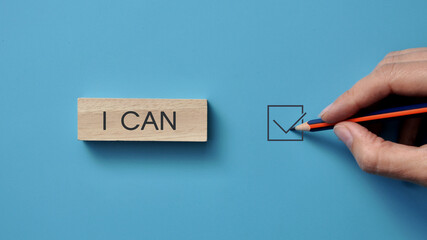 wooden cube with the inscription: I can. A person motivates himself for something