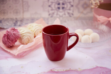 Delicate pink and white marshmallow with decoration and cup of tea. Top view. Winter aesthetic. Cozy winter weekends. Homemade sweets