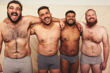 Fototapeta na wymiar Studio shot of shirtless men embracing each other