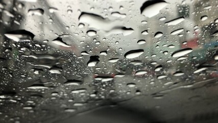 Rain falling on car windshield,drive car on street in city at heavy rain storm,selective focus.
