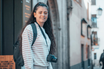 Adolescente turista trotamundos viajando por la ciudad de Venecia junto con su cámara fotográfica para hacer una sesión de fotos de su viaje junto con su mochila y equipaje 