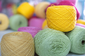 Knitting needles, colorful threads. Knitting pattern of colorful yarn wool on shopfront. Knitting background. Knitting yarn for handmade winter clothes. Colorful background with yarn ball.