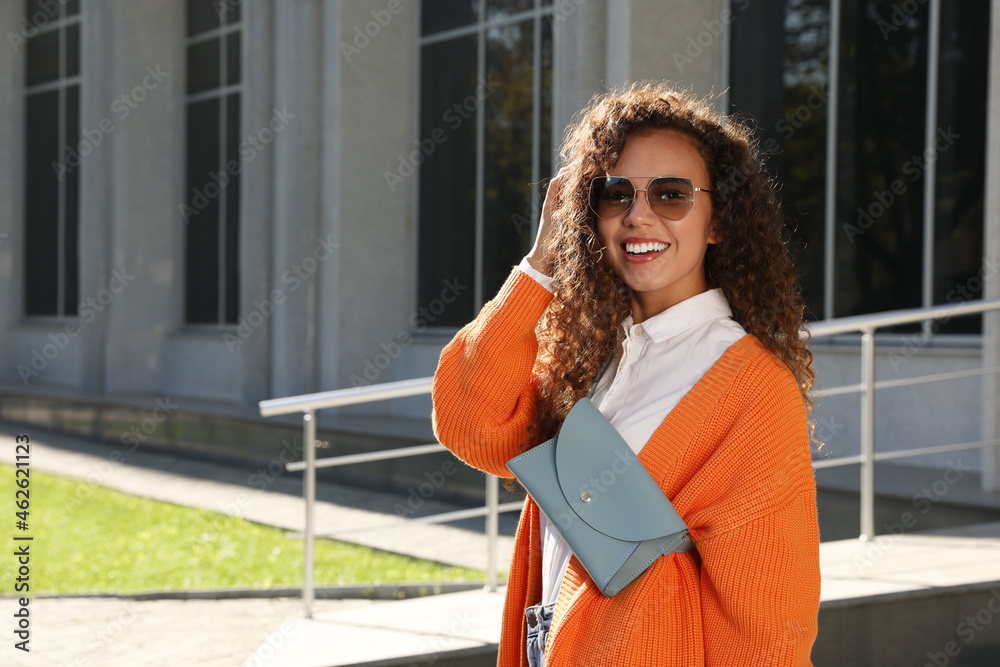 Canvas Prints Beautiful African American woman with stylish waist bag on city street, space for text