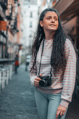 Turista trotamundos indecisa observando establecimientos y locales familiares viajando haciendo fotos profesionales con su cámara y una sonrisa de felicidad para capturar momentos 