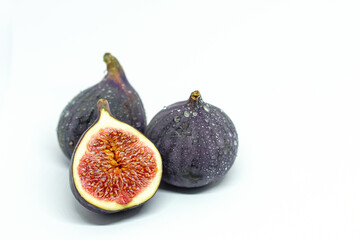 several ripe purple figs on a white background. useful sweets. free copy space
