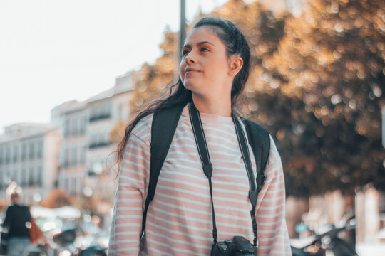 Chica adolescente turista observando la ciudad junto con el paisaje en Paris con su cámara fotográfica para hacer una sesión de fotos profesionales junto con su mochila y equipaje en su viaje