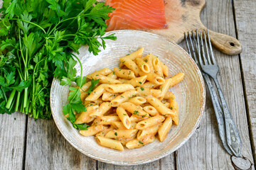  Italian home made   pennette pasta with smoked salmon , creamy sauce and fresh dill on wooden background