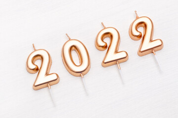 Happy New year and Christmas 2022 celebration. Festive golden number 2022 candles Christmas on white background.