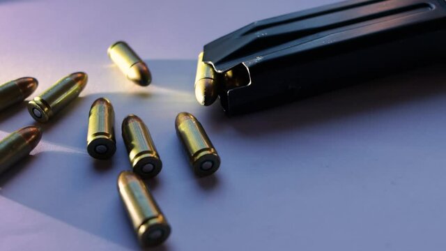 9mm caliber parabellum bullets isolated with grazing light next to a magazine of pistol ammunition