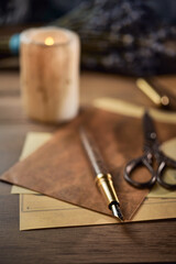 Naklejka premium Vintage writing utensils on a wooden table, old watch, papers, letters, envelopes and scissors