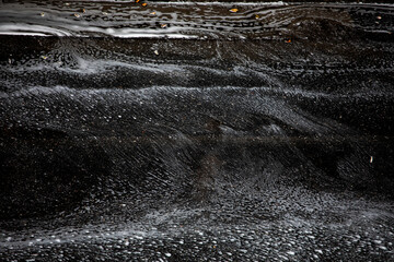 dark abstract background from a stream of water on a car road in a heavy downpour, horizontal,